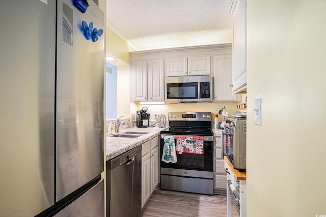 415 Ocean Creek Dr Unit 2373, Myrtle Beach, SC 29572 - kitchen featuring stainless steel appliances, light countertops, white cabinetry, wood finished floors, and a textured ceiling