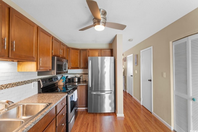 1011 Hunter Ave Unit 1, North Myrtle Beach, SC 29582 - kitchen featuring appliances with stainless steel finishes, brown cabinets, backsplash, and light wood finished floors