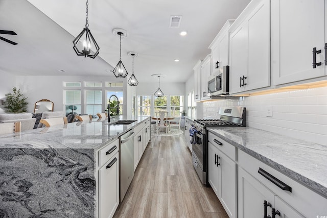 5540 Whitebark Dr, Myrtle Beach, SC 29577 - kitchen featuring stainless steel appliances, tasteful backsplash, white cabinetry, light stone countertops, and recessed lighting