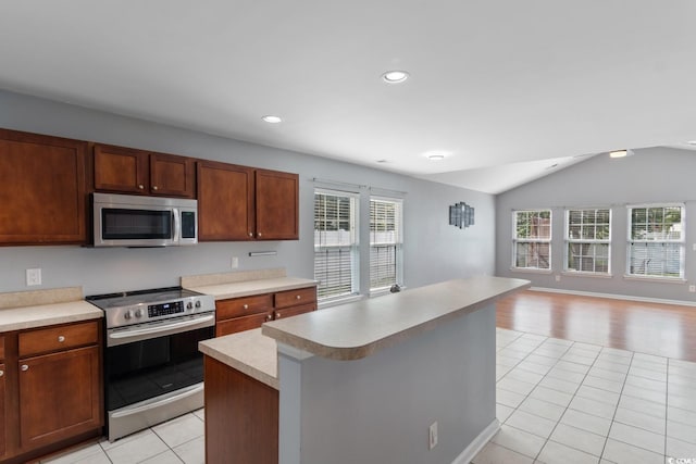 632 Kindred Dr, Myrtle Beach, SC 29588 - kitchen with stainless steel appliances, open floor plan, light tile patterned floors, light countertops, and lofted ceiling