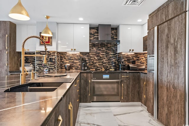 603 S Ocean Blvd Unit 1109, North Myrtle Beach, SC 29582 - kitchen featuring modern cabinets, built in appliances, light marble finish floors, wall chimney exhaust hood, and white cabinetry