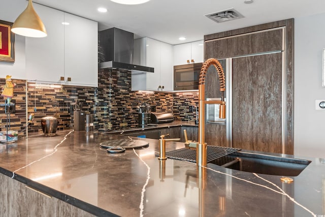 603 S Ocean Blvd Unit 1109, North Myrtle Beach, SC 29582 - kitchen featuring wall chimney range hood, white cabinets, decorative backsplash, stainless steel microwave, and recessed lighting
