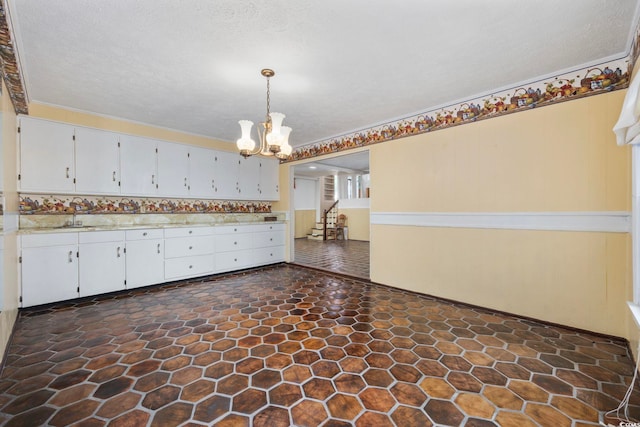 708 Charlotte Rd, Myrtle Beach, SC 29577 - unfurnished room featuring a chandelier, dark stone finish floors, and stairs