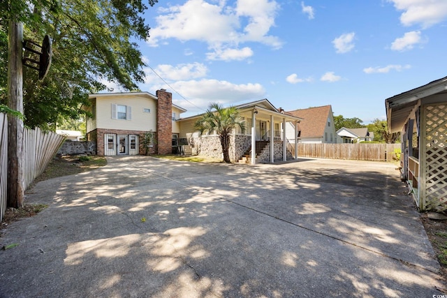 708 Charlotte Rd, Myrtle Beach, SC 29577 - back of house with driveway, stairway, a chimney, a porch, and brick siding