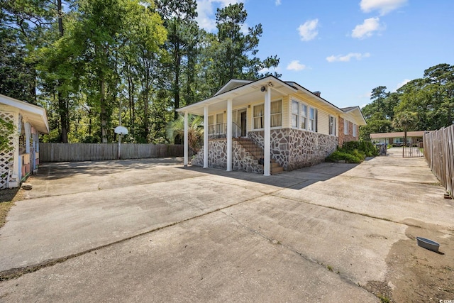 708 Charlotte Rd, Myrtle Beach, SC 29577 - view of home's exterior featuring a porch, stone siding, driveway, and stairway