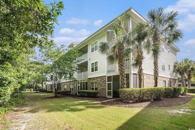 6253 Catalina Dr Unit 1113, North Myrtle Beach, SC 29582 - view of side of property featuring brick siding and a lawn