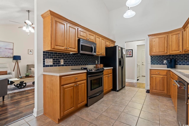 188 Governors Loop, Myrtle Beach, SC 29588 - kitchen featuring appliances with stainless steel finishes, light countertops, a towering ceiling, light tile patterned flooring, and tasteful backsplash