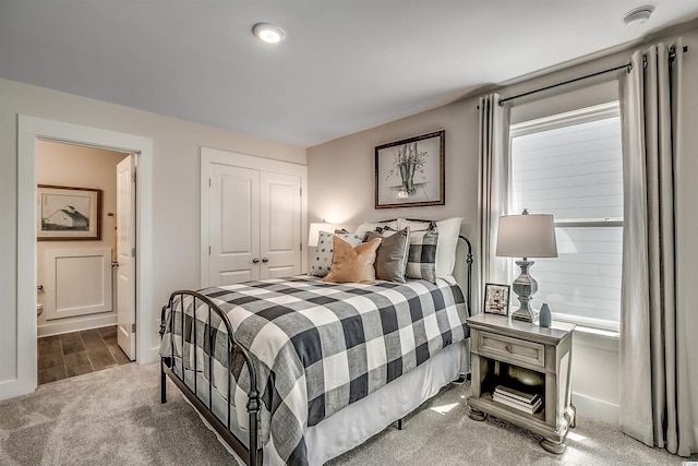 carpeted bedroom with a closet and ensuite bathroom