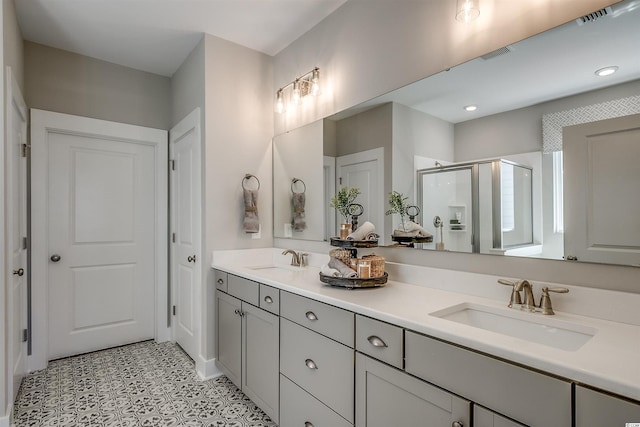 bathroom featuring dual vanity, tile flooring, and a shower with shower door