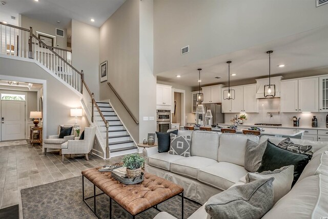 living room featuring light hardwood / wood-style floors and a towering ceiling