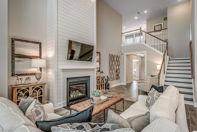 living room with a towering ceiling and dark hardwood / wood-style flooring