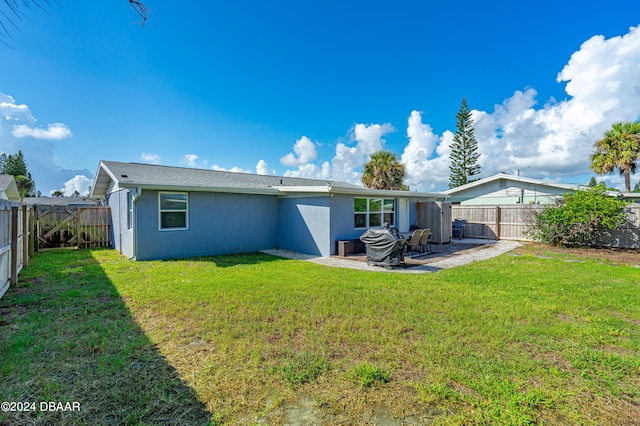 rear view of house with a yard and a patio area