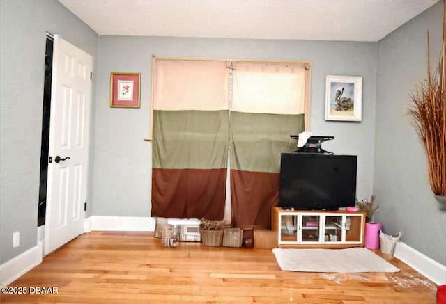 interior space featuring baseboards and wood finished floors