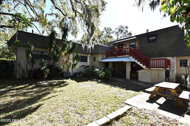 back of house featuring a patio area, stairway, and a yard