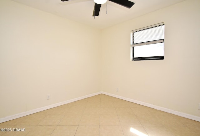 spare room with light tile patterned floors, a ceiling fan, and baseboards