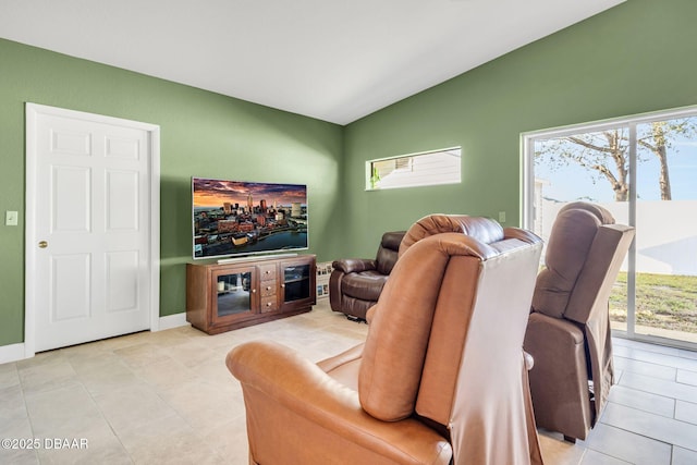 living room featuring vaulted ceiling, plenty of natural light, light tile patterned flooring, and baseboards