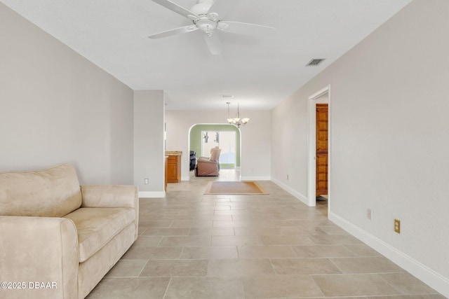 interior space with arched walkways, visible vents, baseboards, and ceiling fan with notable chandelier