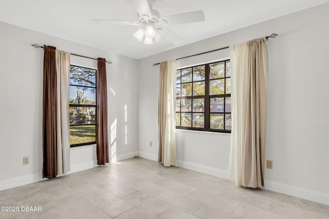 spare room featuring ceiling fan and baseboards