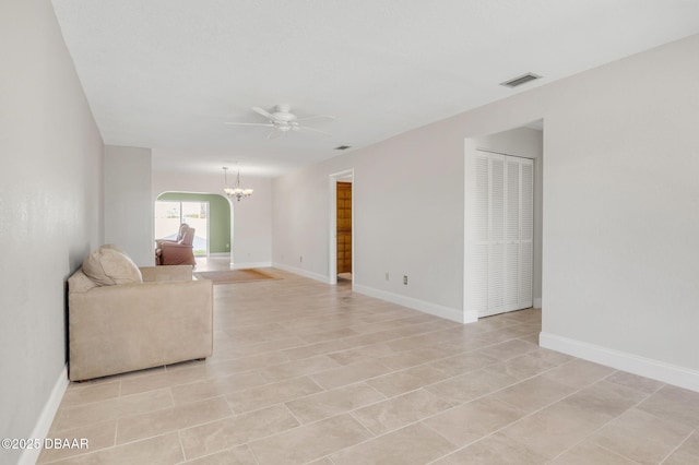 unfurnished living room with baseboards, visible vents, and ceiling fan with notable chandelier