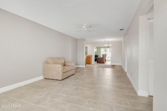 unfurnished room with visible vents, baseboards, and ceiling fan with notable chandelier