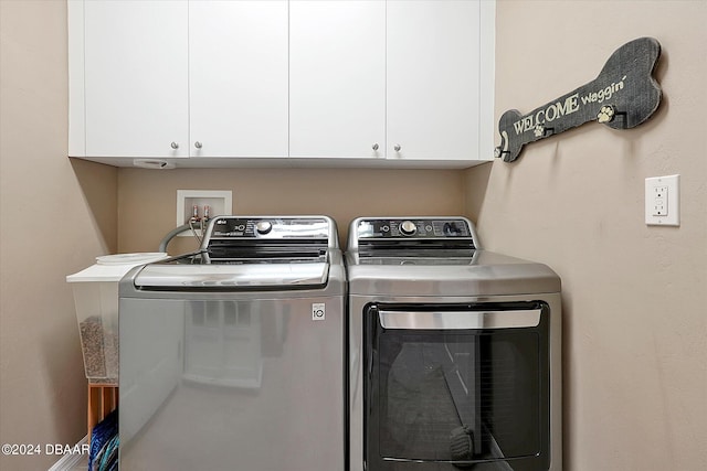 laundry room featuring cabinets and washing machine and clothes dryer