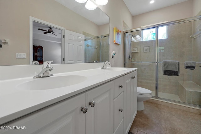 bathroom with tile patterned floors, a shower with door, vanity, toilet, and ceiling fan