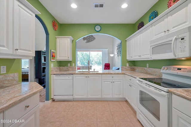 kitchen with white cabinetry, white appliances, sink, and light tile patterned flooring