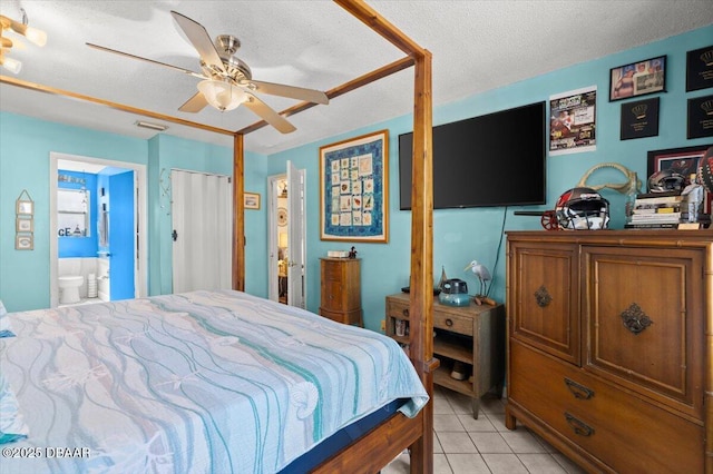 bedroom with ceiling fan, a textured ceiling, ensuite bath, and light tile patterned flooring