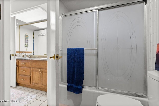 bathroom with vanity, tile patterned floors, toilet, and combined bath / shower with glass door