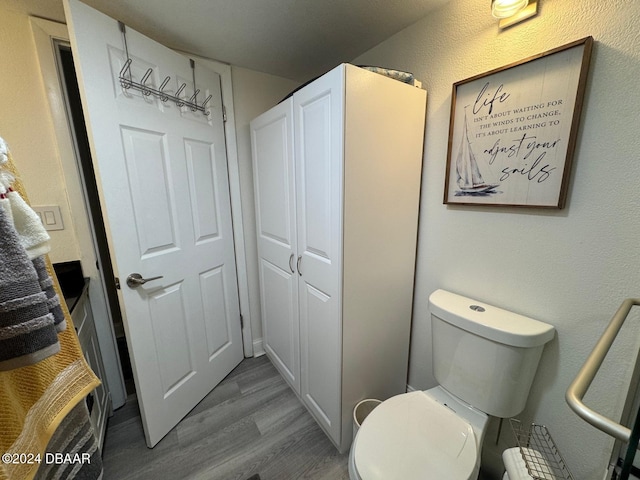 bathroom featuring hardwood / wood-style flooring and toilet