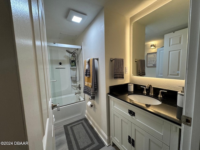 bathroom with combined bath / shower with glass door and vanity