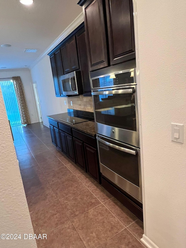 kitchen with decorative backsplash, appliances with stainless steel finishes, dark brown cabinets, crown molding, and dark tile patterned flooring