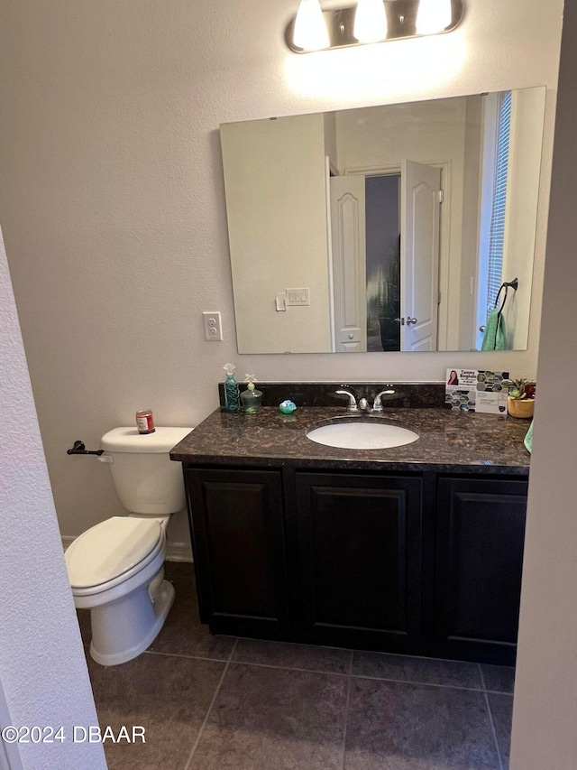 bathroom featuring toilet, vanity, and tile patterned floors