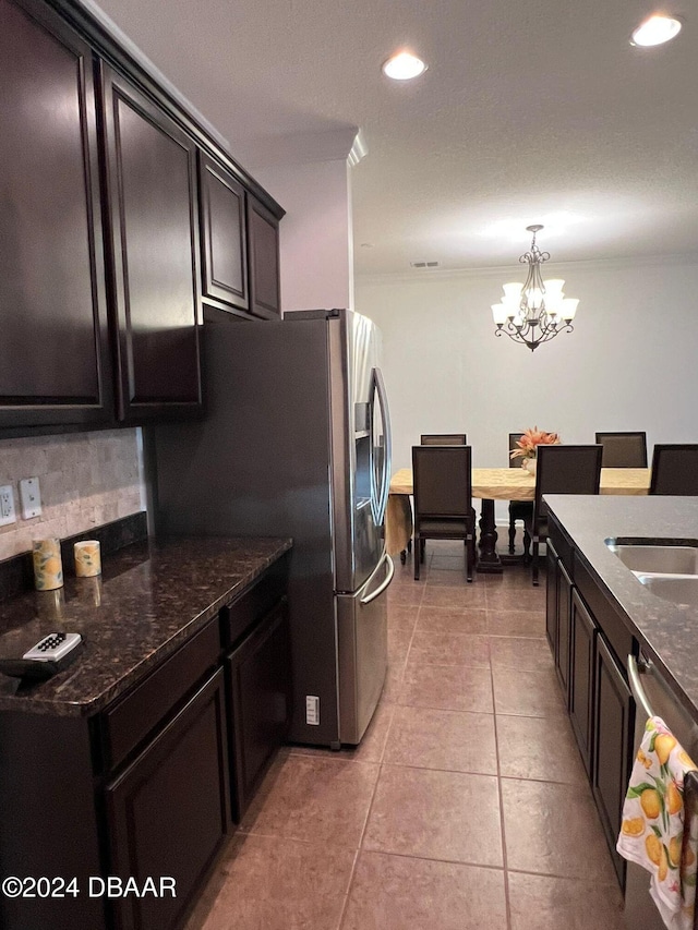 kitchen with backsplash, dark stone counters, a notable chandelier, hanging light fixtures, and light tile patterned flooring