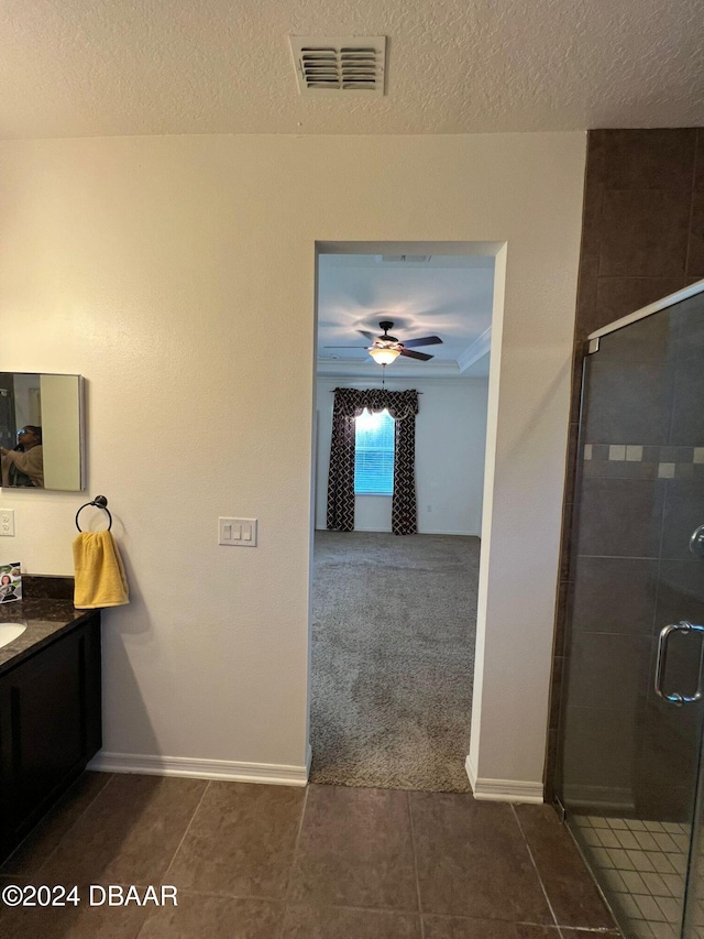 bathroom with vanity, tile patterned floors, ceiling fan, a textured ceiling, and an enclosed shower