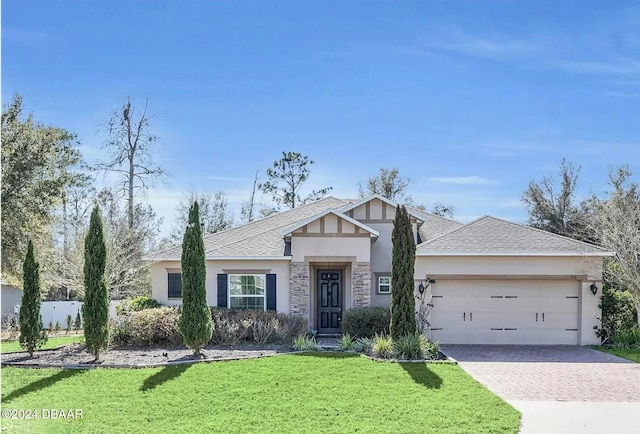 view of front of property featuring a garage and a front lawn