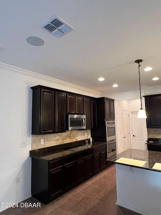 kitchen featuring pendant lighting, tile patterned floors, decorative backsplash, ornamental molding, and appliances with stainless steel finishes