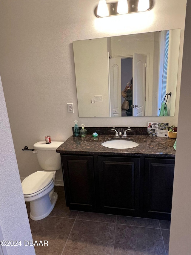 bathroom featuring toilet, vanity, and tile patterned floors