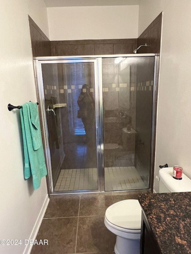 bathroom with tile patterned floors, vanity, walk in shower, and toilet