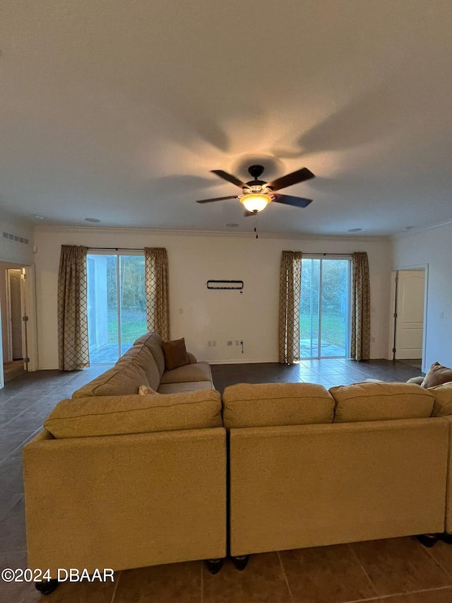 tiled living room featuring ceiling fan, crown molding, and a wealth of natural light