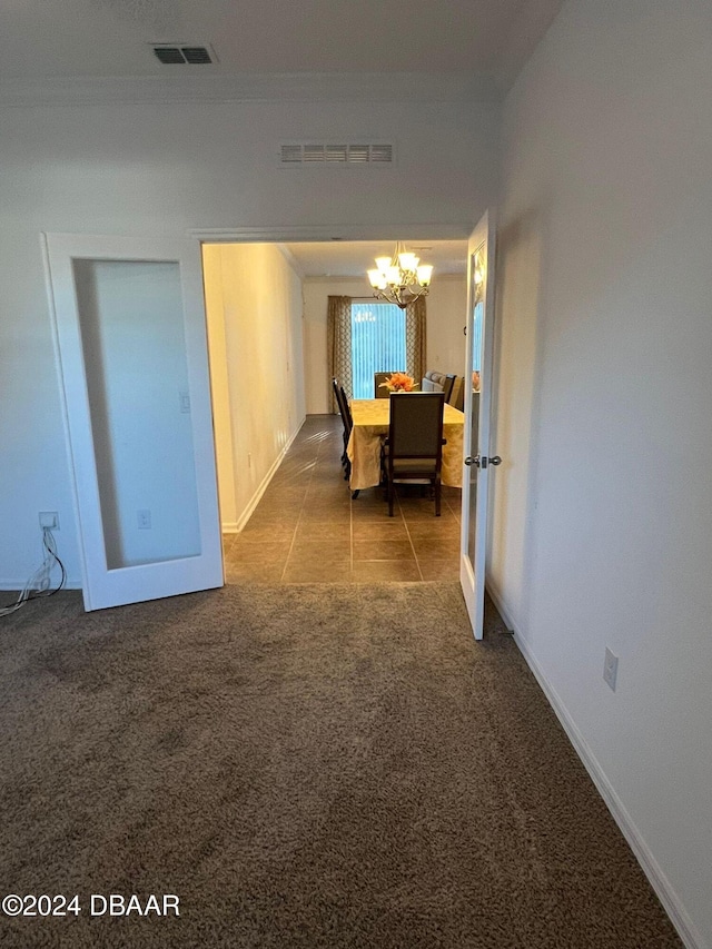 corridor with carpet flooring and a chandelier