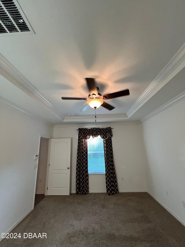 empty room featuring ceiling fan, carpet floors, and crown molding