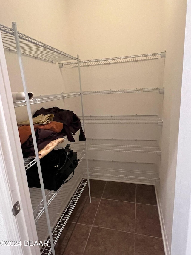 spacious closet with dark tile patterned floors