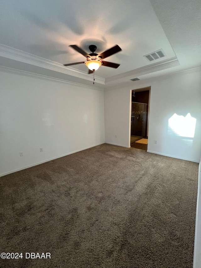 unfurnished room with carpet floors, a raised ceiling, and ornamental molding