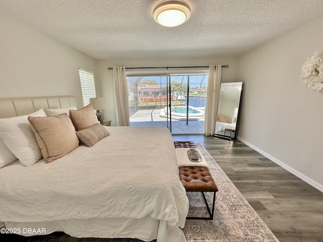 bedroom featuring access to outside, multiple windows, a textured ceiling, and dark wood-type flooring
