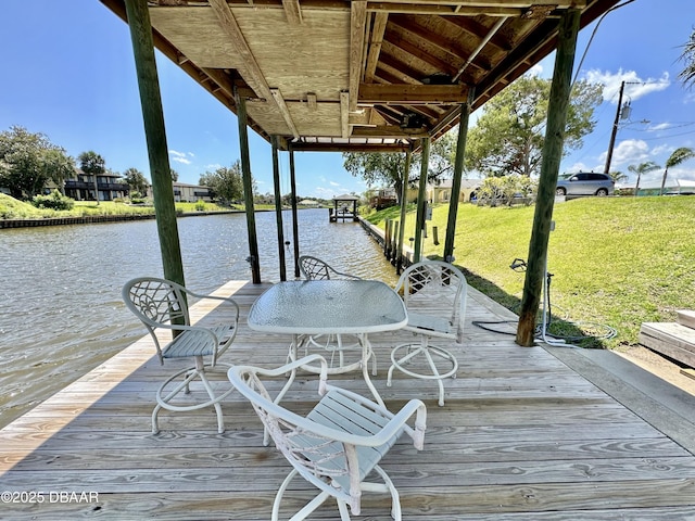 view of dock featuring a water view and a yard