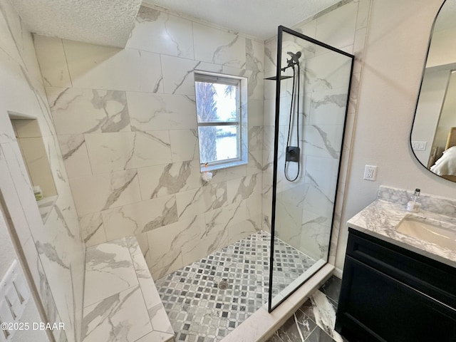 full bathroom featuring a textured ceiling, a marble finish shower, marble finish floor, and vanity