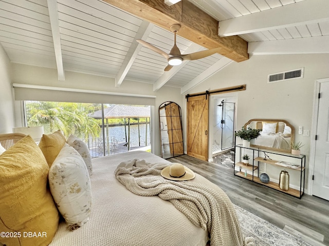 bedroom featuring visible vents, a barn door, wood finished floors, lofted ceiling with beams, and access to outside