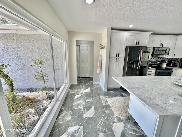 kitchen with electric range, white cabinetry, stainless steel microwave, baseboards, and fridge with ice dispenser