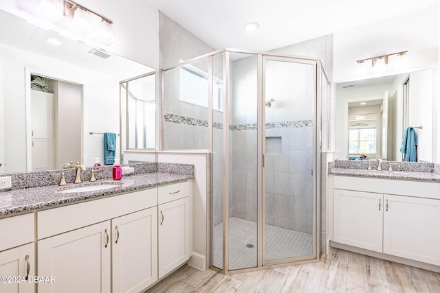 bathroom with vanity, hardwood / wood-style floors, and a shower with door